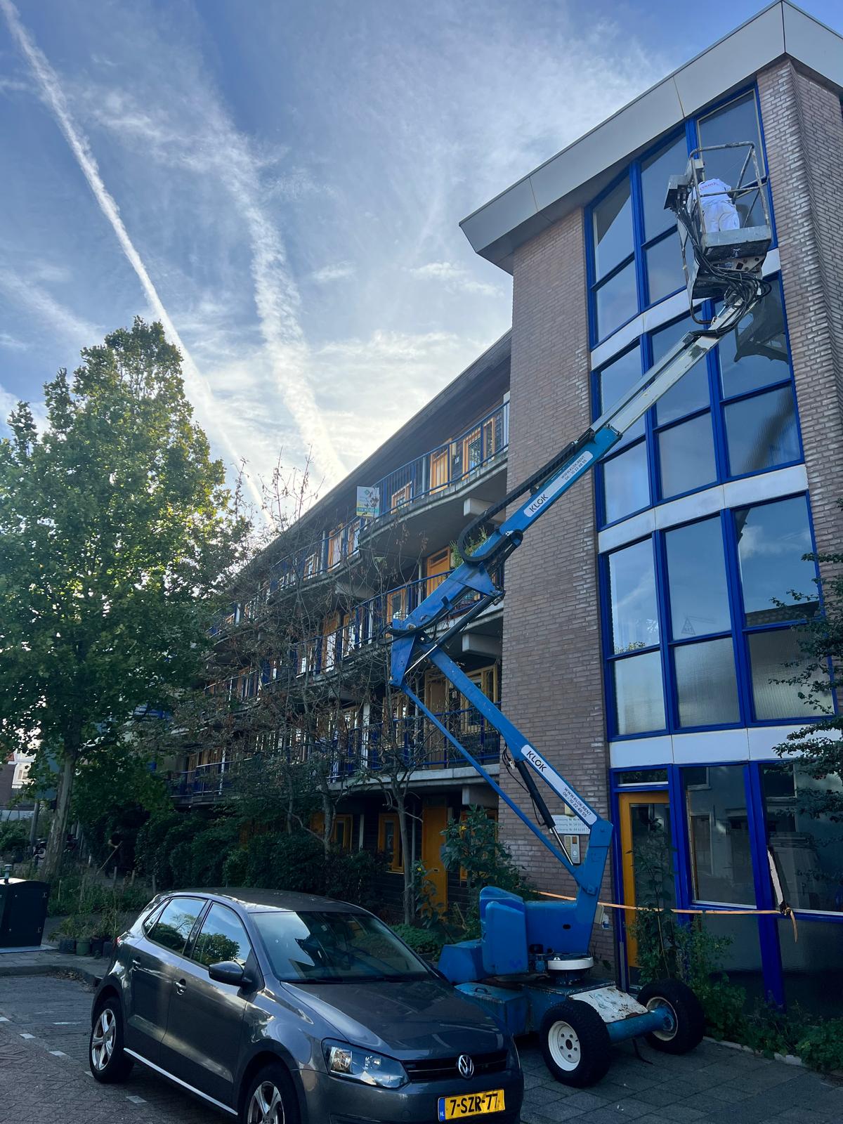 Appartementencomplex met hoogwerker tijdens buitenschilderwerk voor VvE