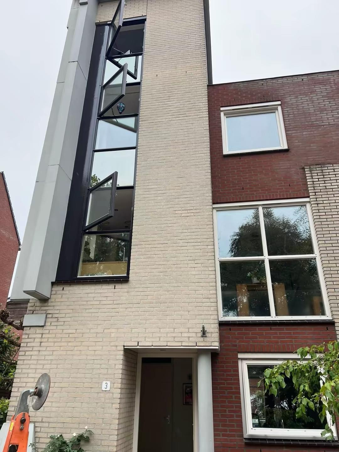 Zijgevel hoekwoning in Delft met geschilderde ramen en kozijnen