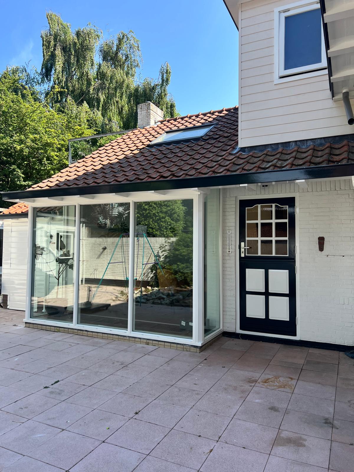 Achtergevel woning met geschilderde schuifpui en deur