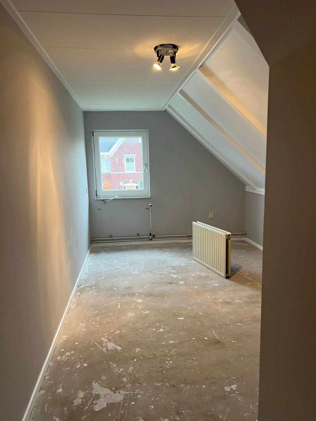 Overzicht van kamer met geschilderde muren en plafond vanuit de gang