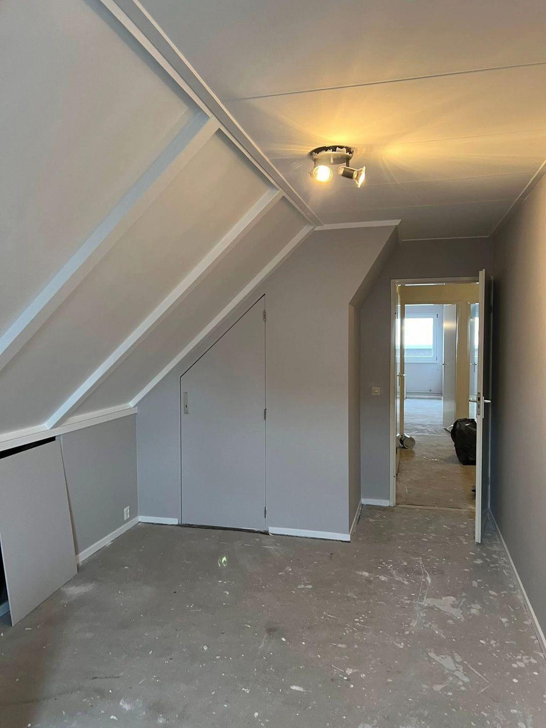 Kamer met blauw tapijt en strak geschilderde muren en plinten