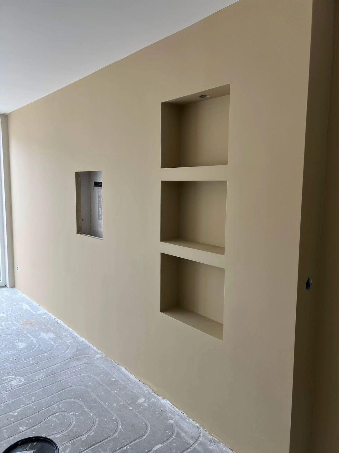 Woonkamerwand met nissen in warme tint in Zoetermeer