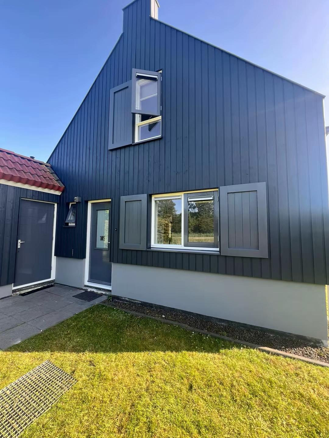 Voorgevel van geschilderde villa in Zoetermeer met donker houtwerk en grijze kozijnen