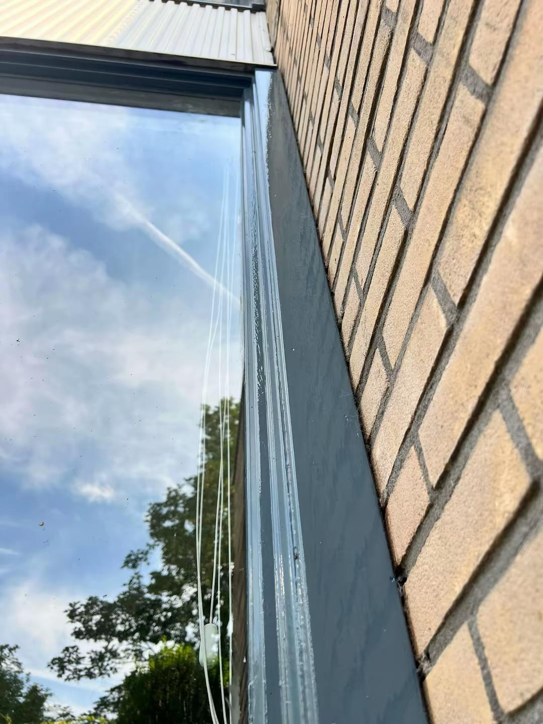Detail van geschilderd kozijn aan bakstenen gevel in Delft