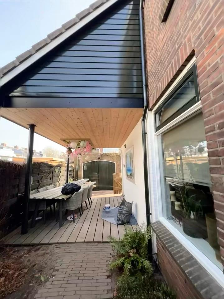 Achtergevel met geschilderde rabatdelen en veranda in Rotterdam