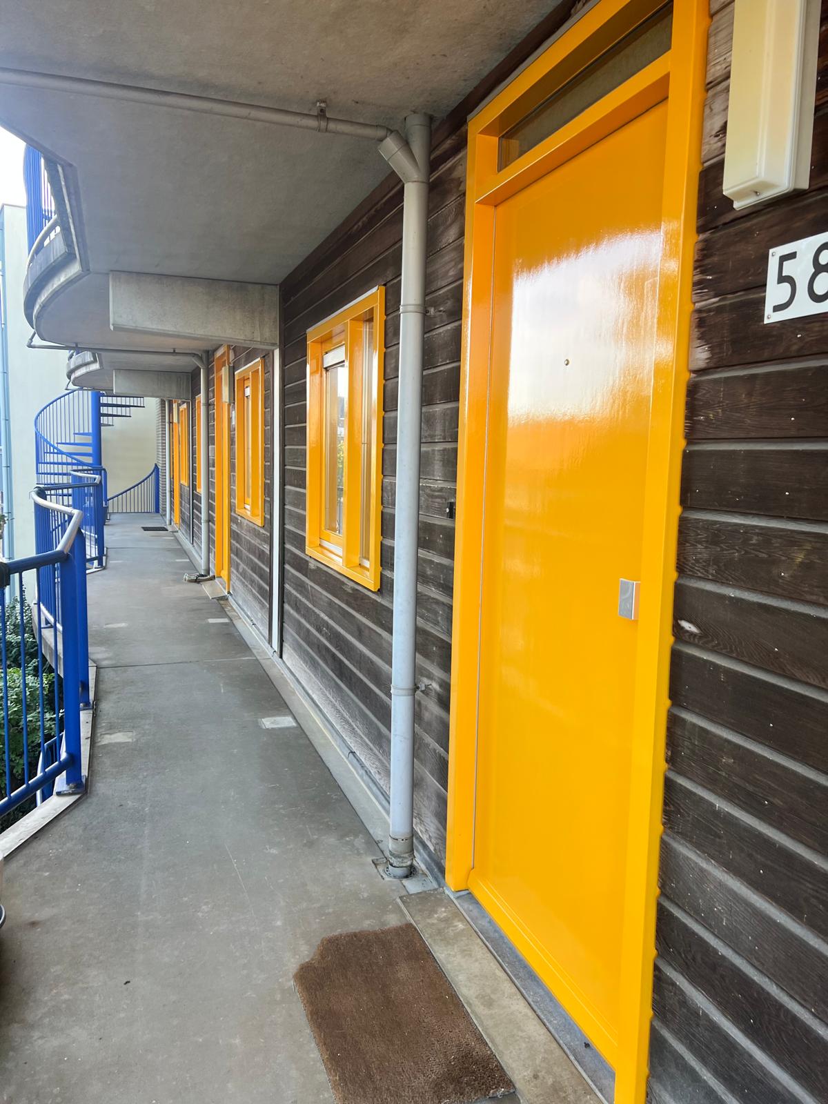 Gele voordeur en ramen na het buitenschilderwerk