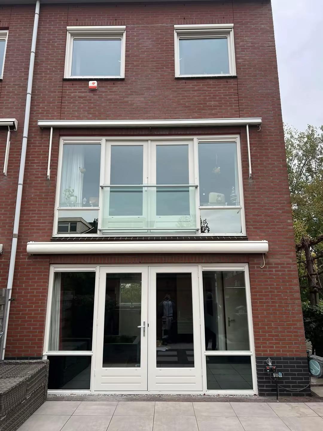 Achtergevel hoekwoning in Delft met geschilderde tuindeuren en kozijnen