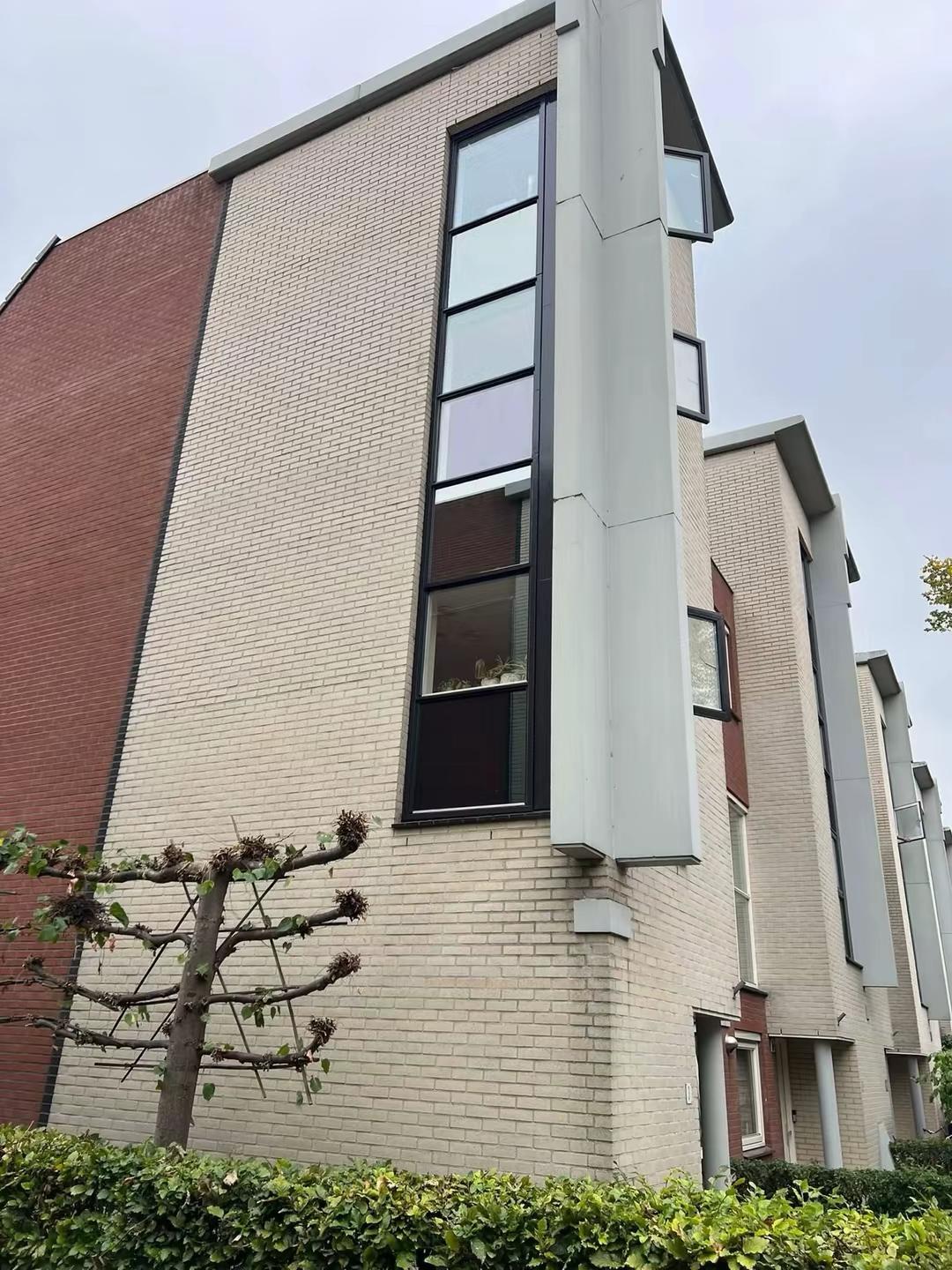 Hoekwoning in Delft met geschilderde ramen en kozijnen na buitenschilderwerk