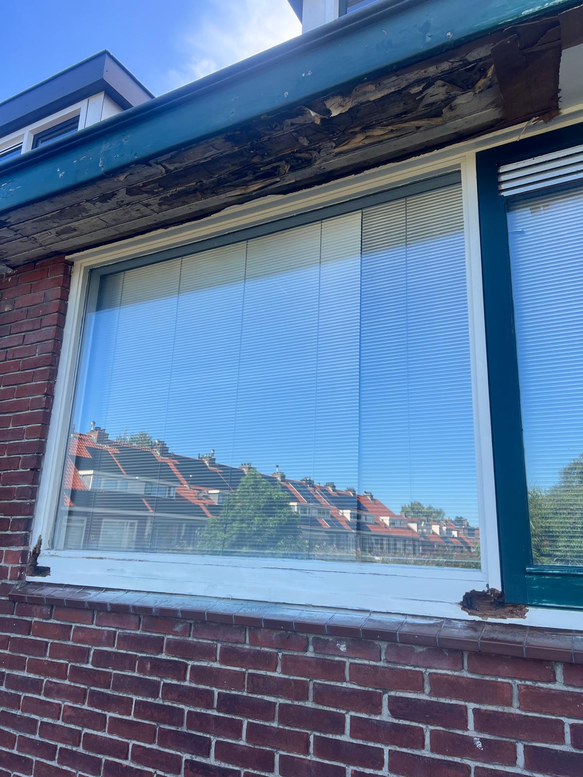 Houtrot aan kozijnhoeken en dakoverstek vóór de reparatie