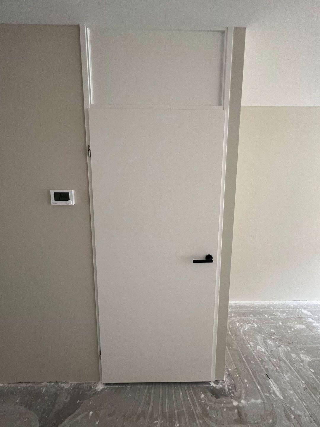 Geschilderde binnendeur met zwarte deurkruk in Zoetermeer